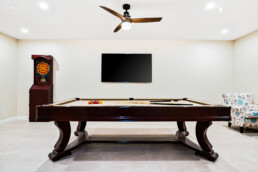 Recreation and billiards room with pool table, darts game and lounge chair.